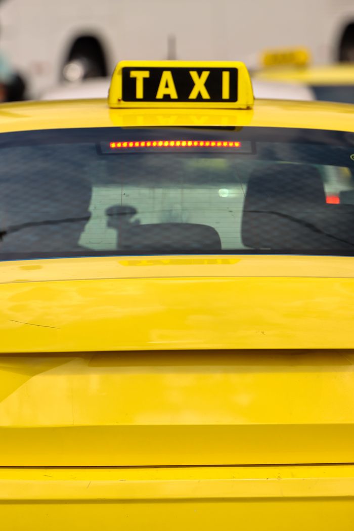 gallery-5 Close-up of a yellow taxi in Athens, Greece, highlighting the bright sign and urban setting.